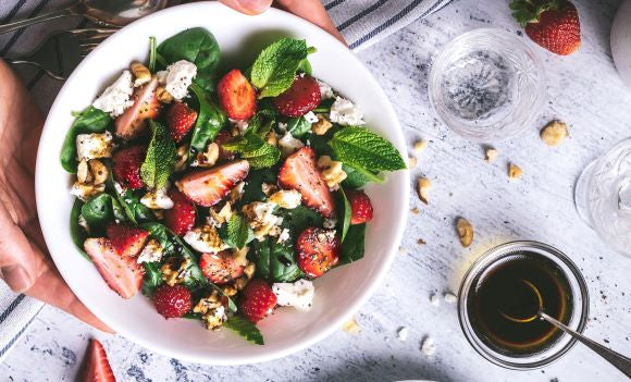 CBD salad dressing next to strawberry salad