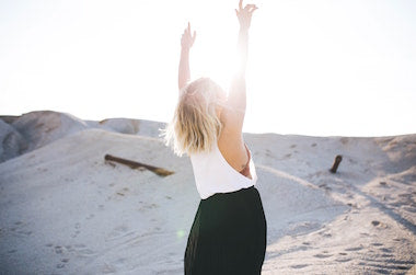 Girl with her arms raised at the beach