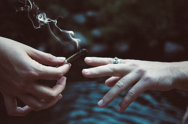 Two people passing a joint