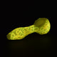 Full shot of 4-inch glass yellow pipe with illuminated glow in the dark swirls black background bowl on right